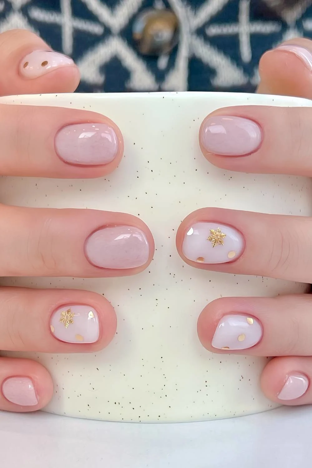 Pink and white manicure with gold snowflakes