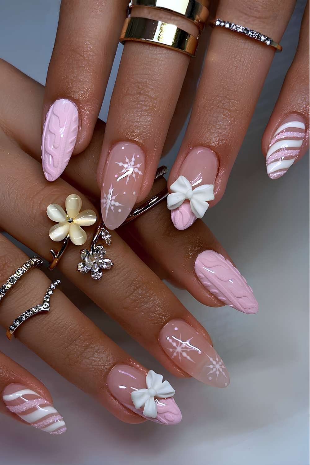 Pink and white nails swith sweater patterns and bows