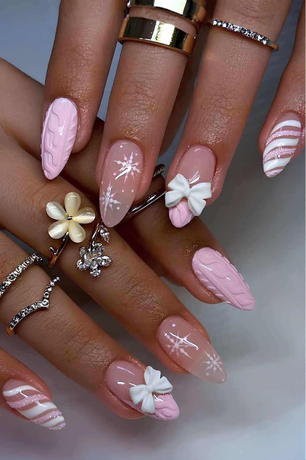 Pink and white nails swith sweater patterns and bows
