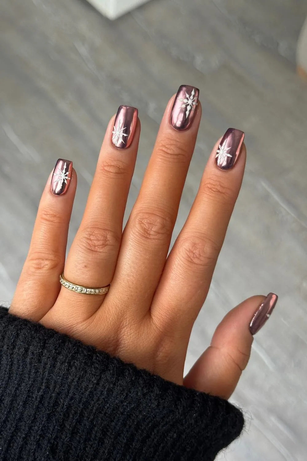 Pink chrome nails with white snowflake details