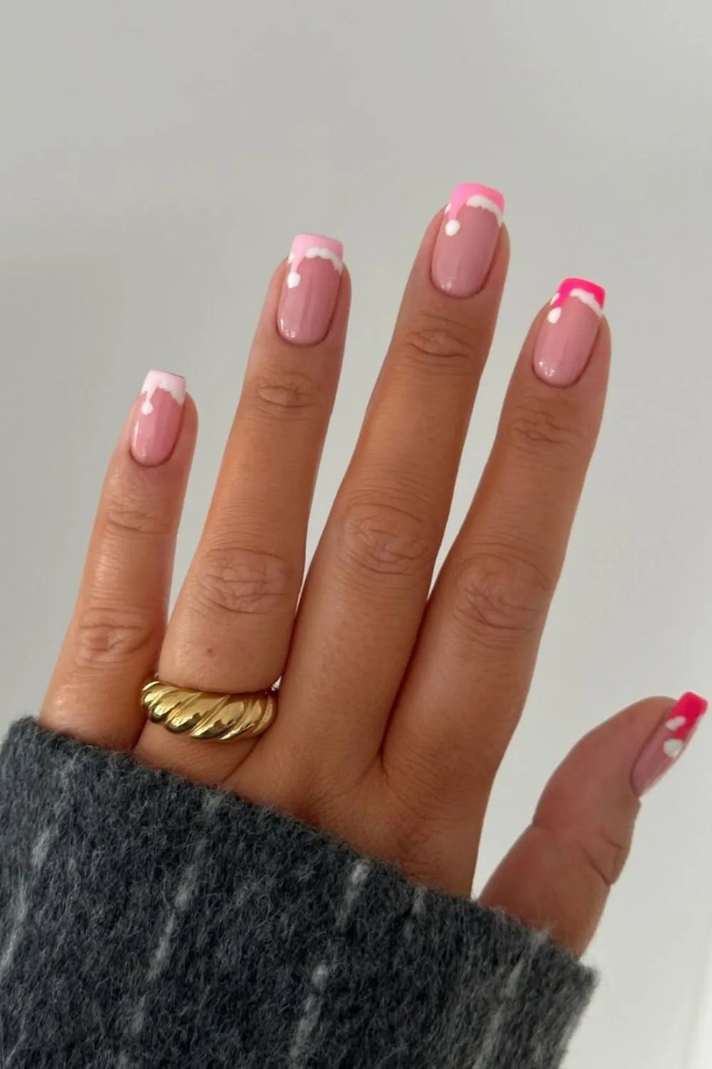 Pink french tip nails with Santa hat accents