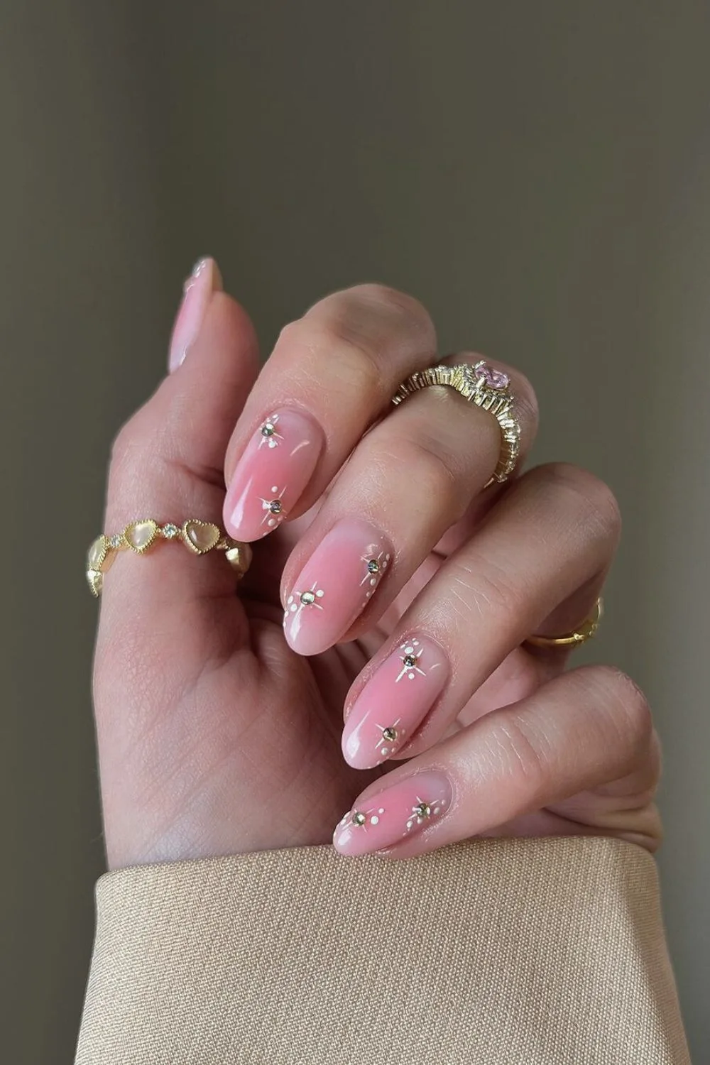 Pink nails with gold chrome stars and studs