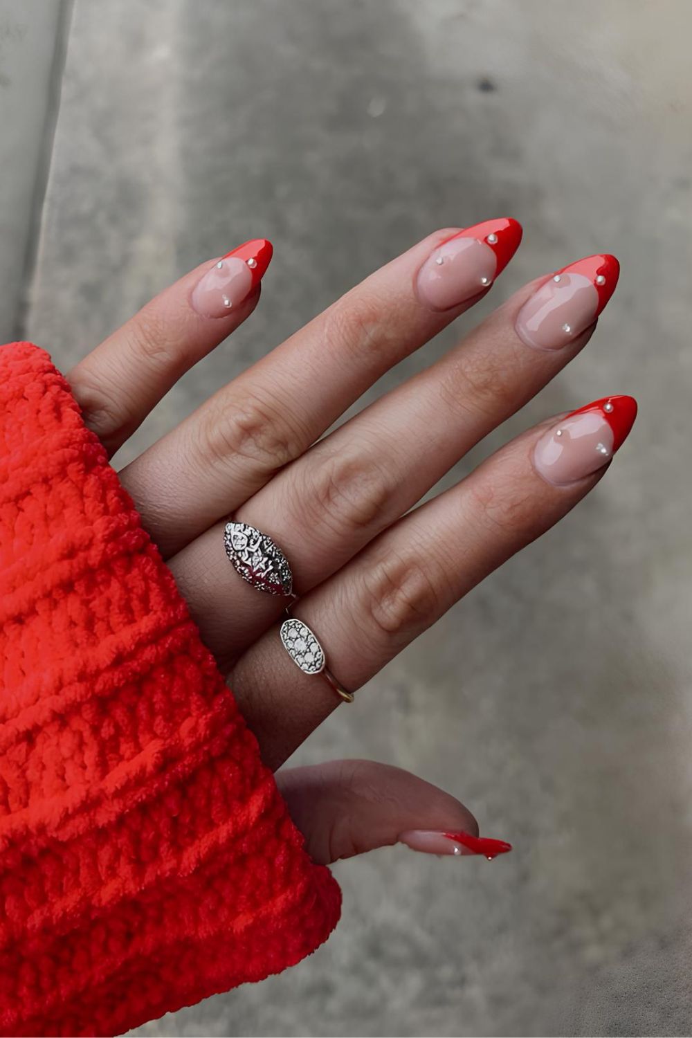 Red French tip nails with pearl accents