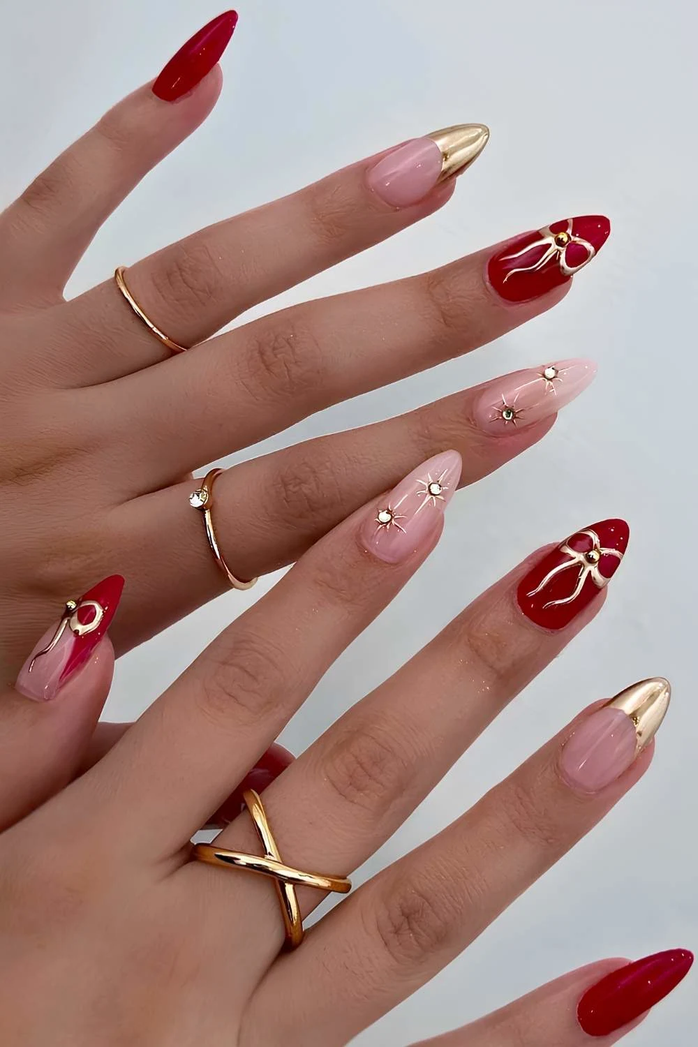 Red and gold nails with rhinestones and bows