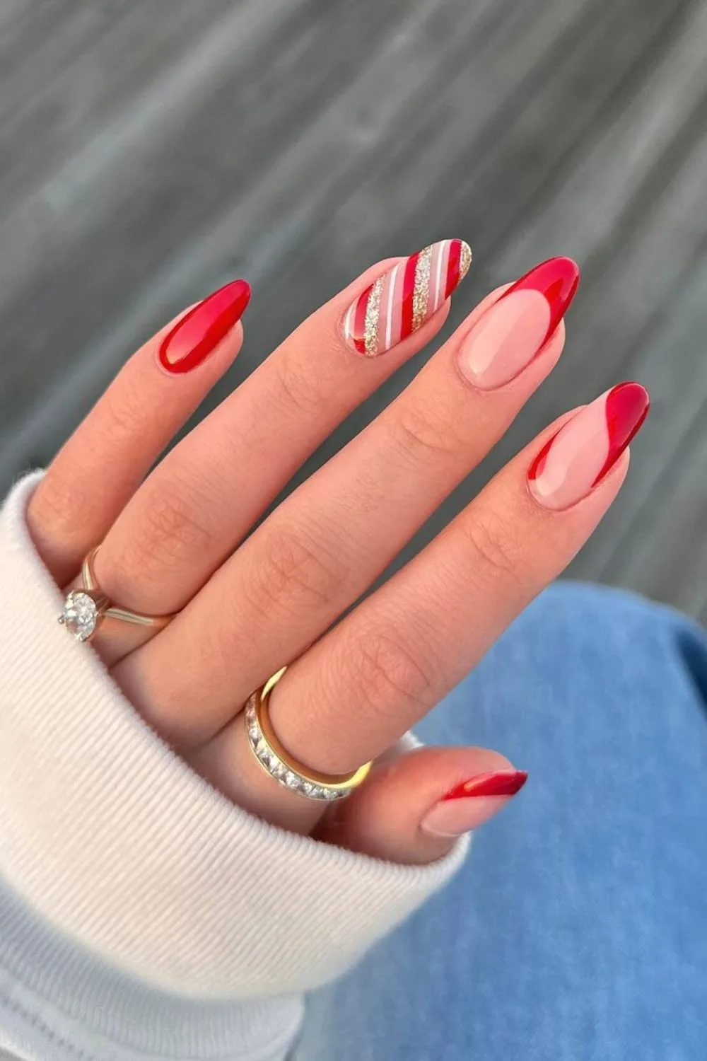 Red negative space nails with gold and red stripes accent