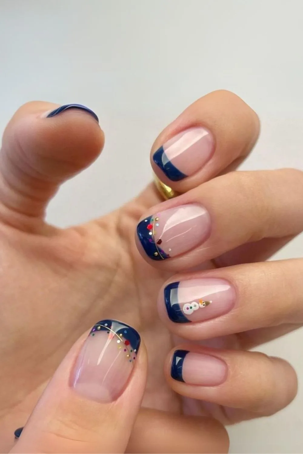 Short navy blue french tip nails with christmas staples