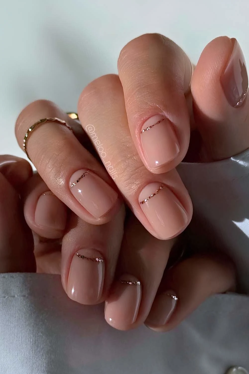 Short sheer nails with glitter half moon outlines