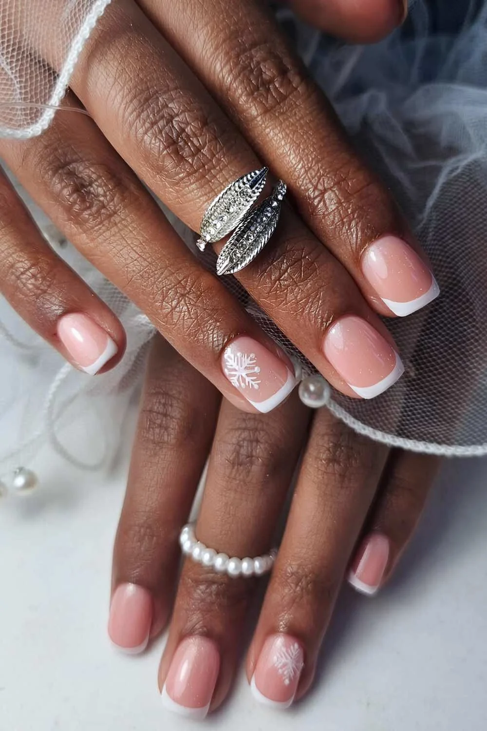 Short white French nails with snowflakes