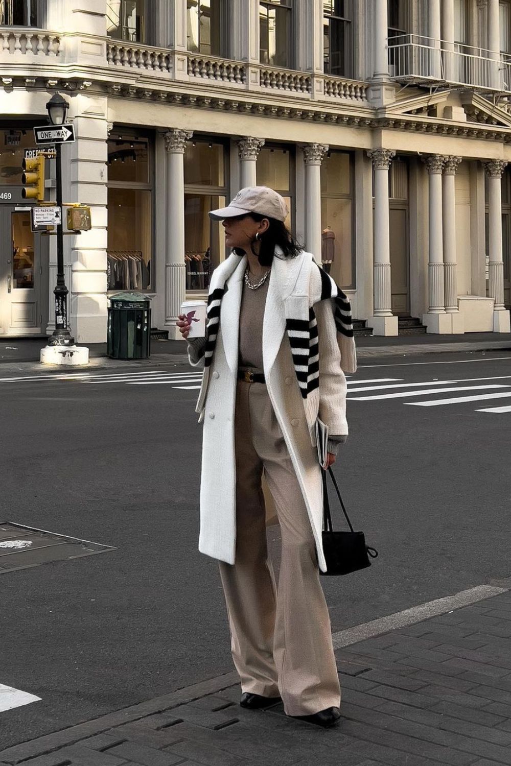 White coat paired with beige wide-leg pants and striped sweater