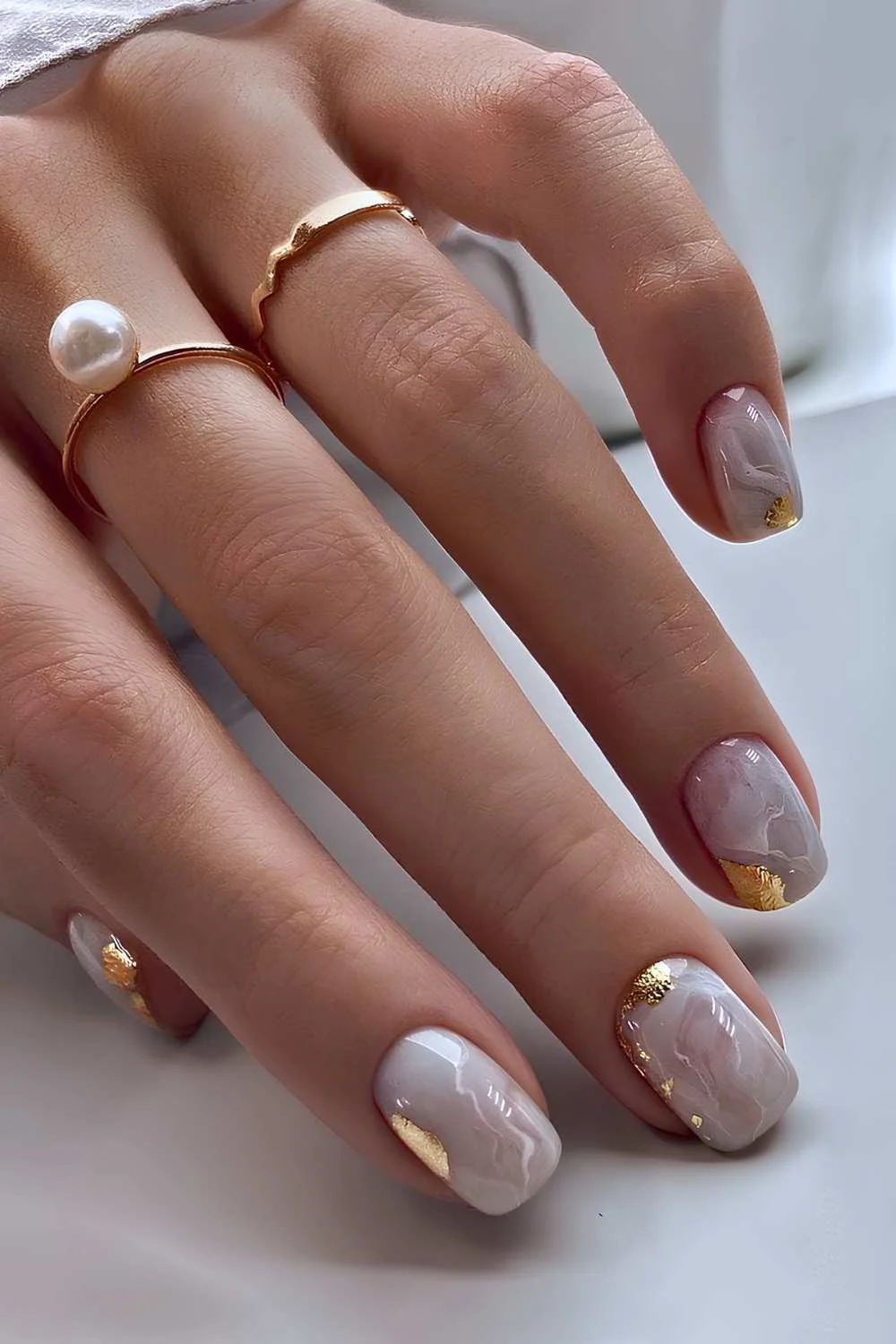 White marble manicure with gold foil details