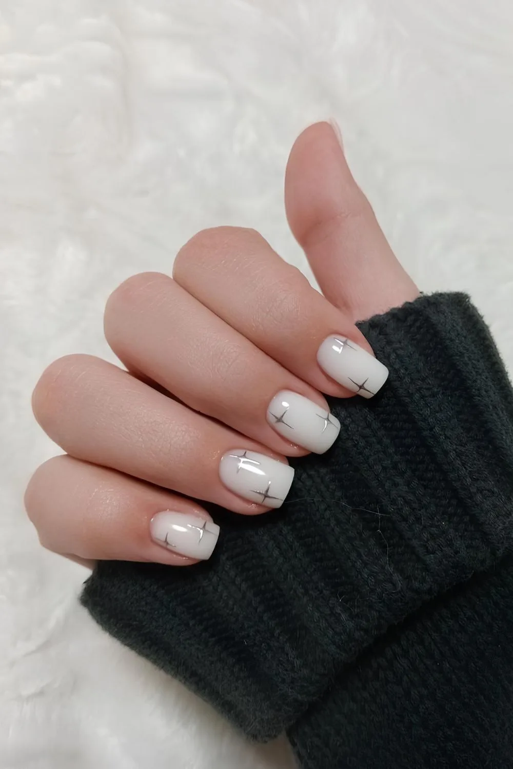 White nails with silver chrome stars