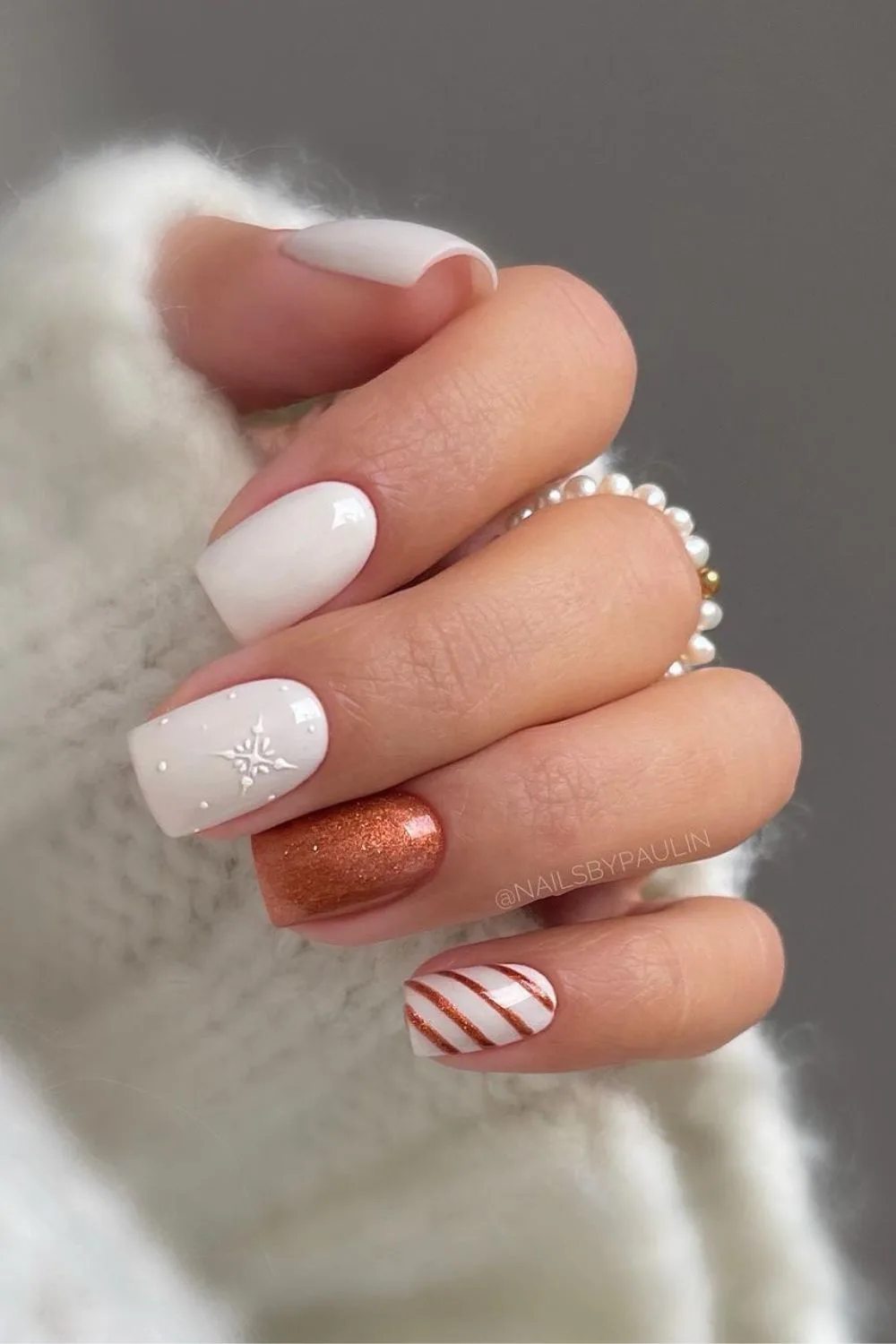 White nails with snowflakes and copper stripes