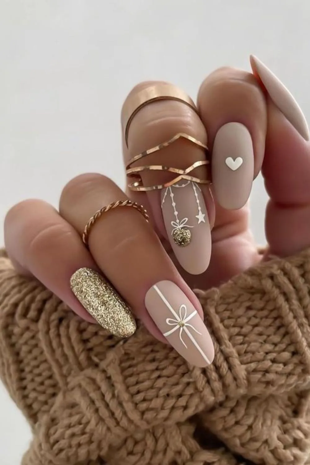 Beige matte nails with gold glitter and Christmas ornaments accent