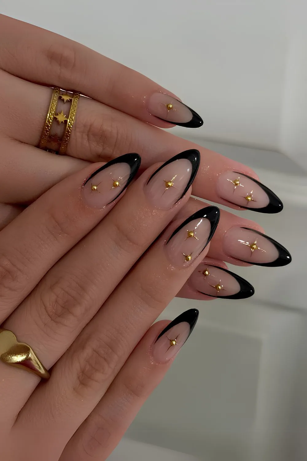 Black French tip nails with gold celestial charms