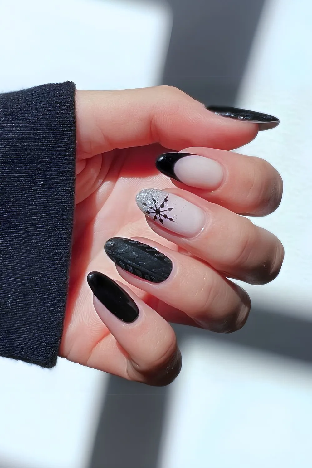 Black nails with sweater pattern and snowflakes