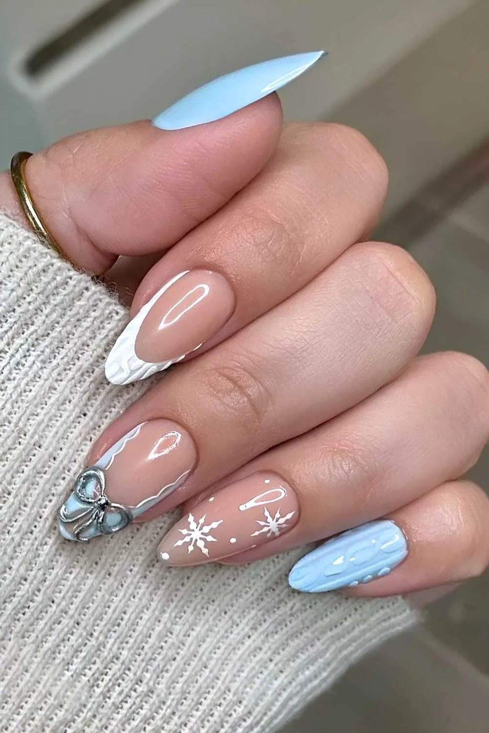 Blue and white nails with sweater patterns and bows
