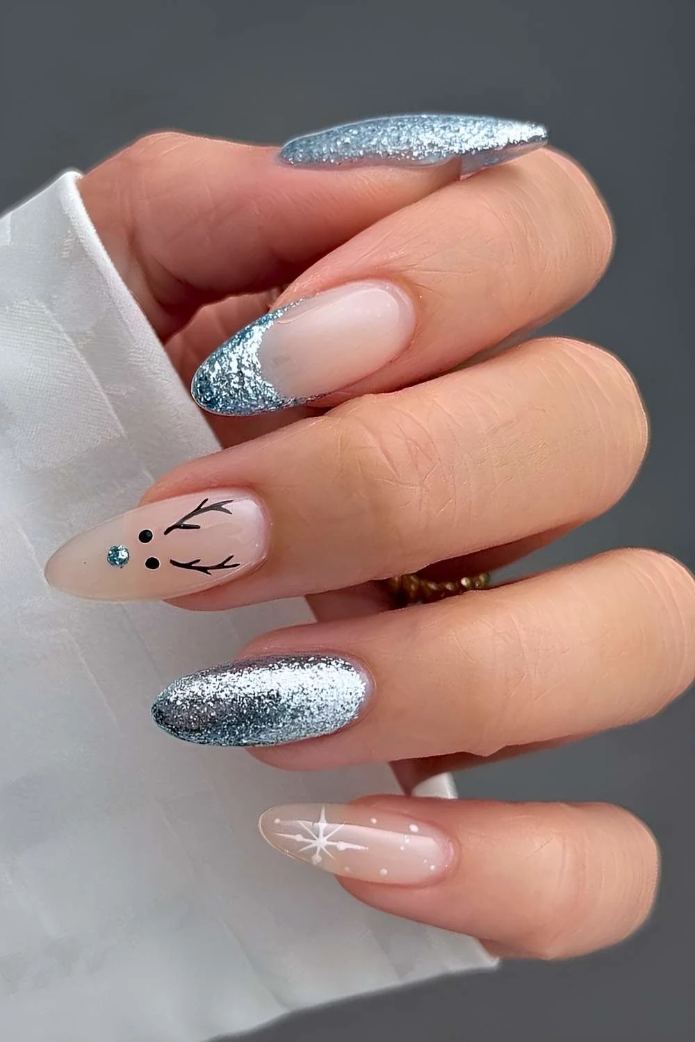 https://thepinkissue.com/wp-content/uploads/2024/12/Blue-glitter-nails-with-reindeer-and-snowflake-art.jpg.webp?utm_source=chatgpt.com