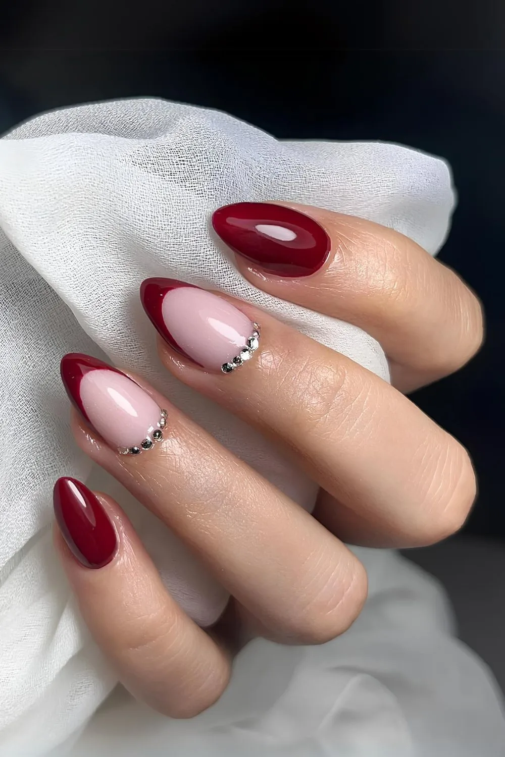 Cherry red nails qith accent French tips and gems