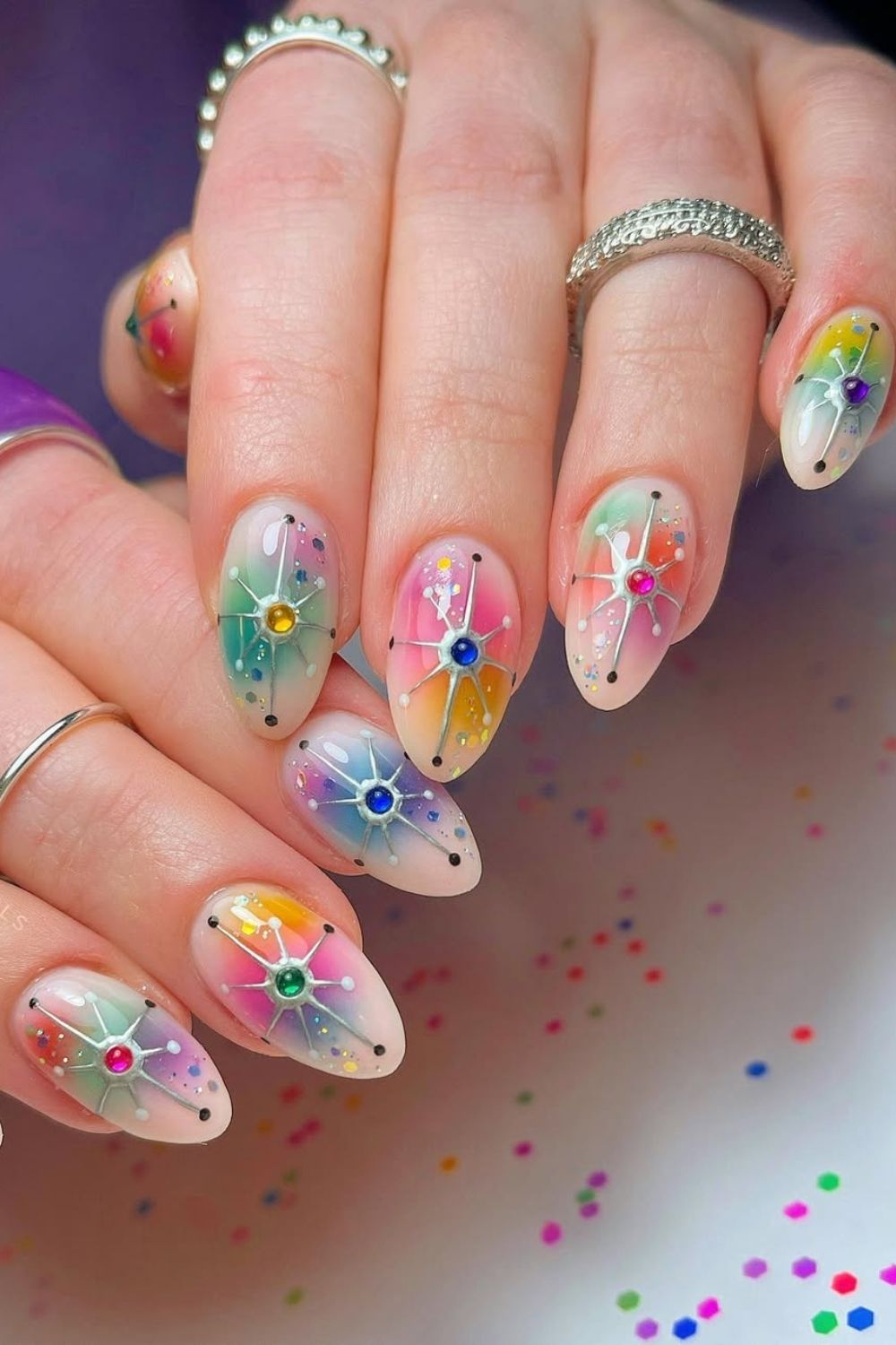 Colorful rainbow nails with confetti and rhinestone accents