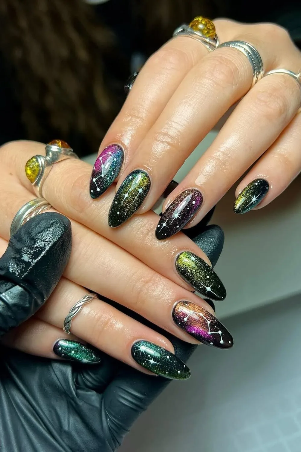 Dark cat-eye nails with stars and shimmer