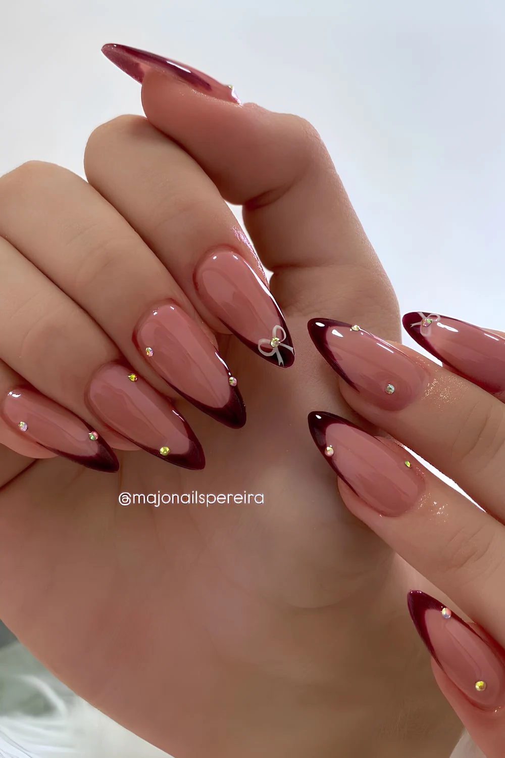 Dark red French mani with bows and rhinestones
