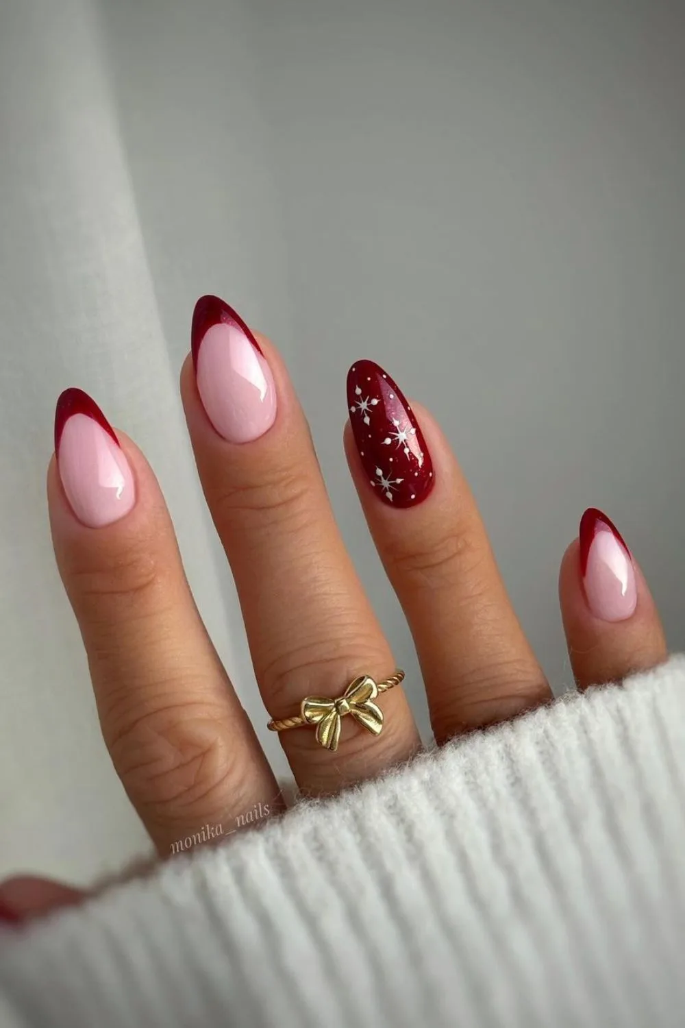 Dark red French tip nails with tiny snowflakes