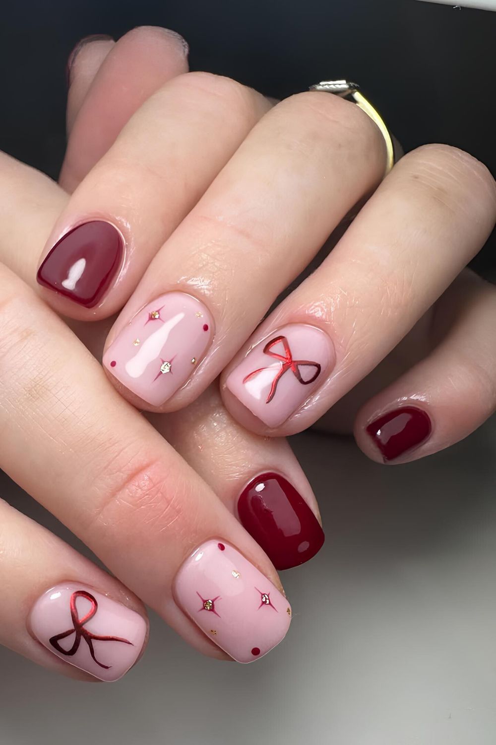 Dark red nails with bows and celestial accents