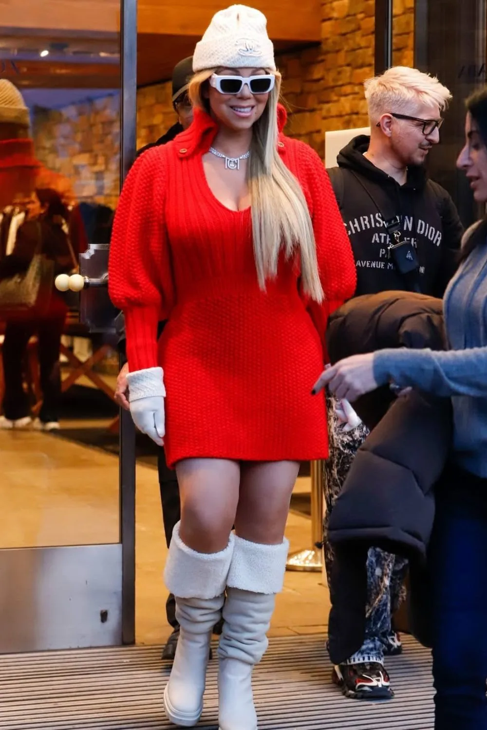 Famous singer Mariah Carey wearing red apres ski outfit, red dress and high-knee boots