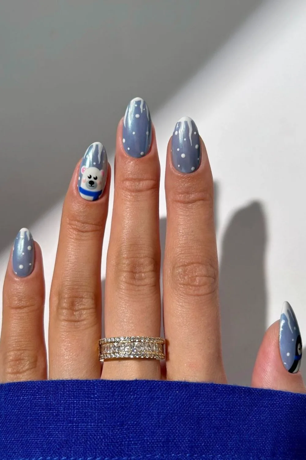 Glazed light blue nails with snowfall dots and dripping white tips with polar bear detail