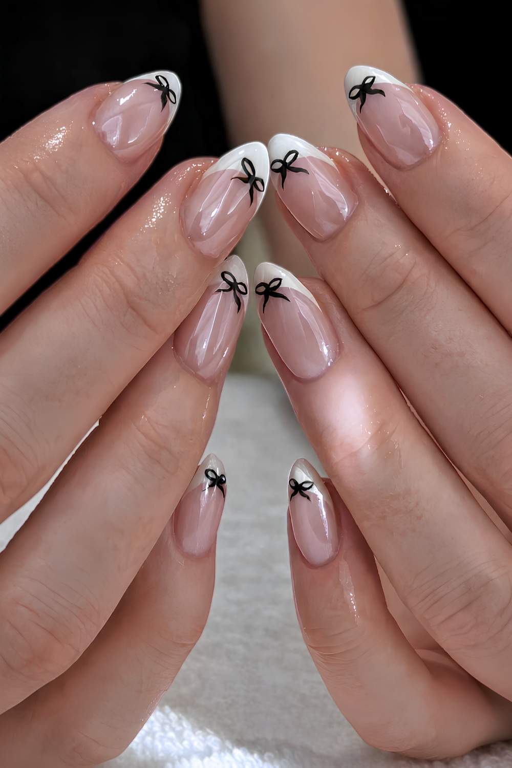 Glazed white French mani with black bows