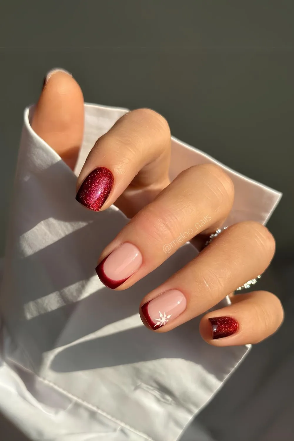 Glittery burgundy nails with snowflakes