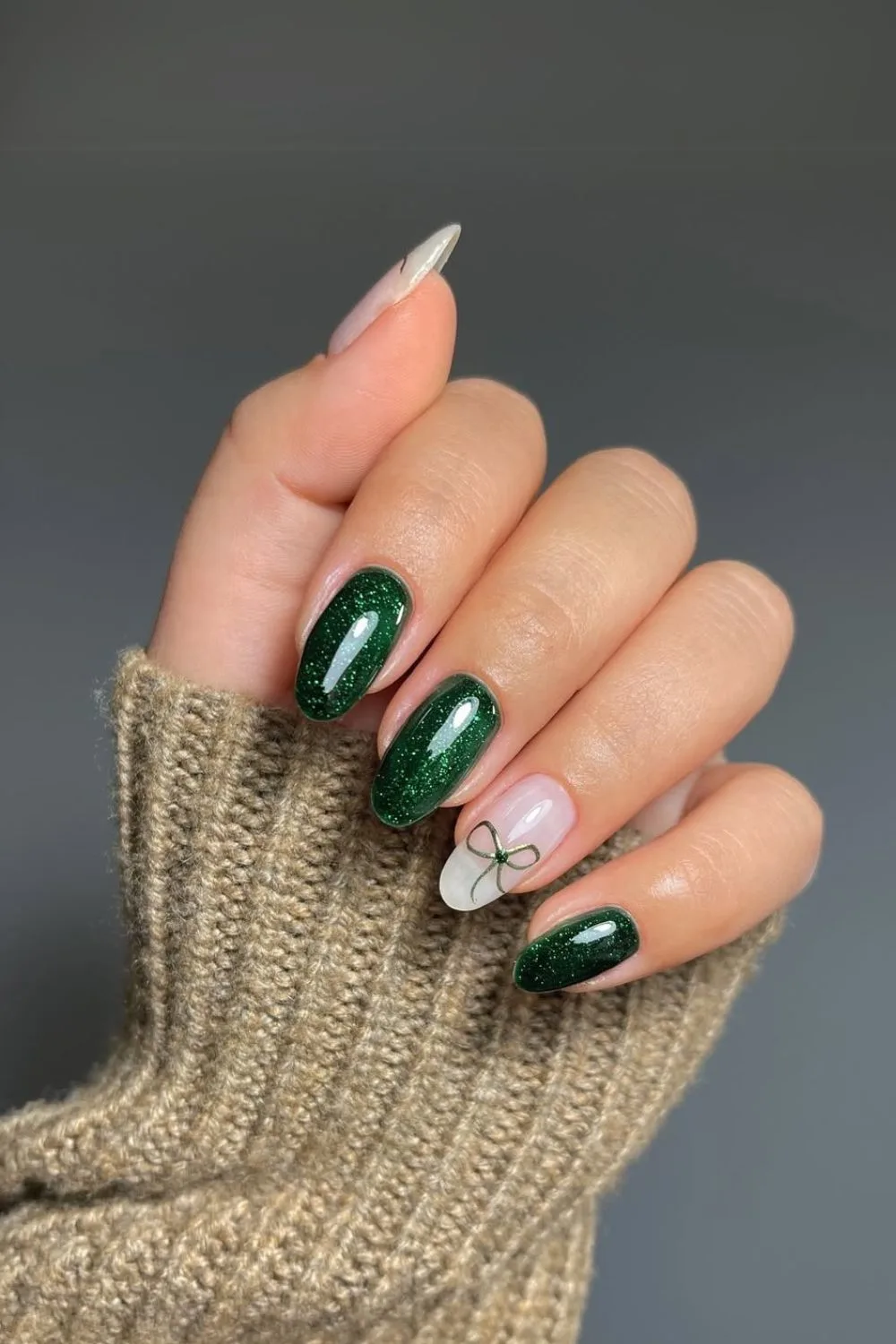 Glittery green nails with coquette bow accent