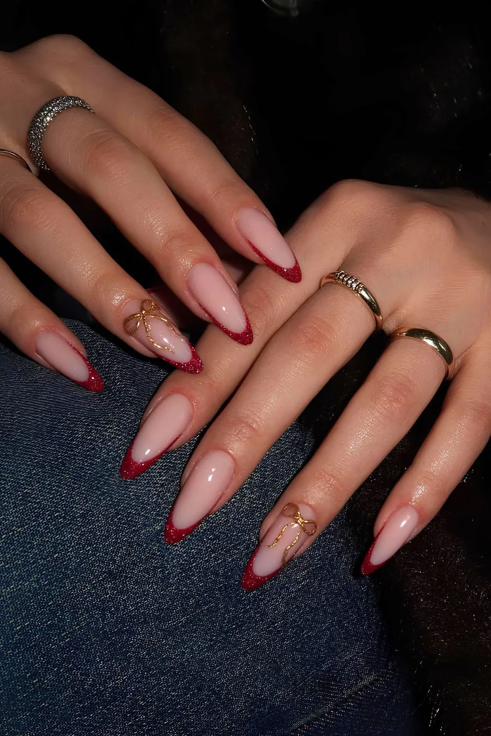 Glittery red French nails with gold coquette bows