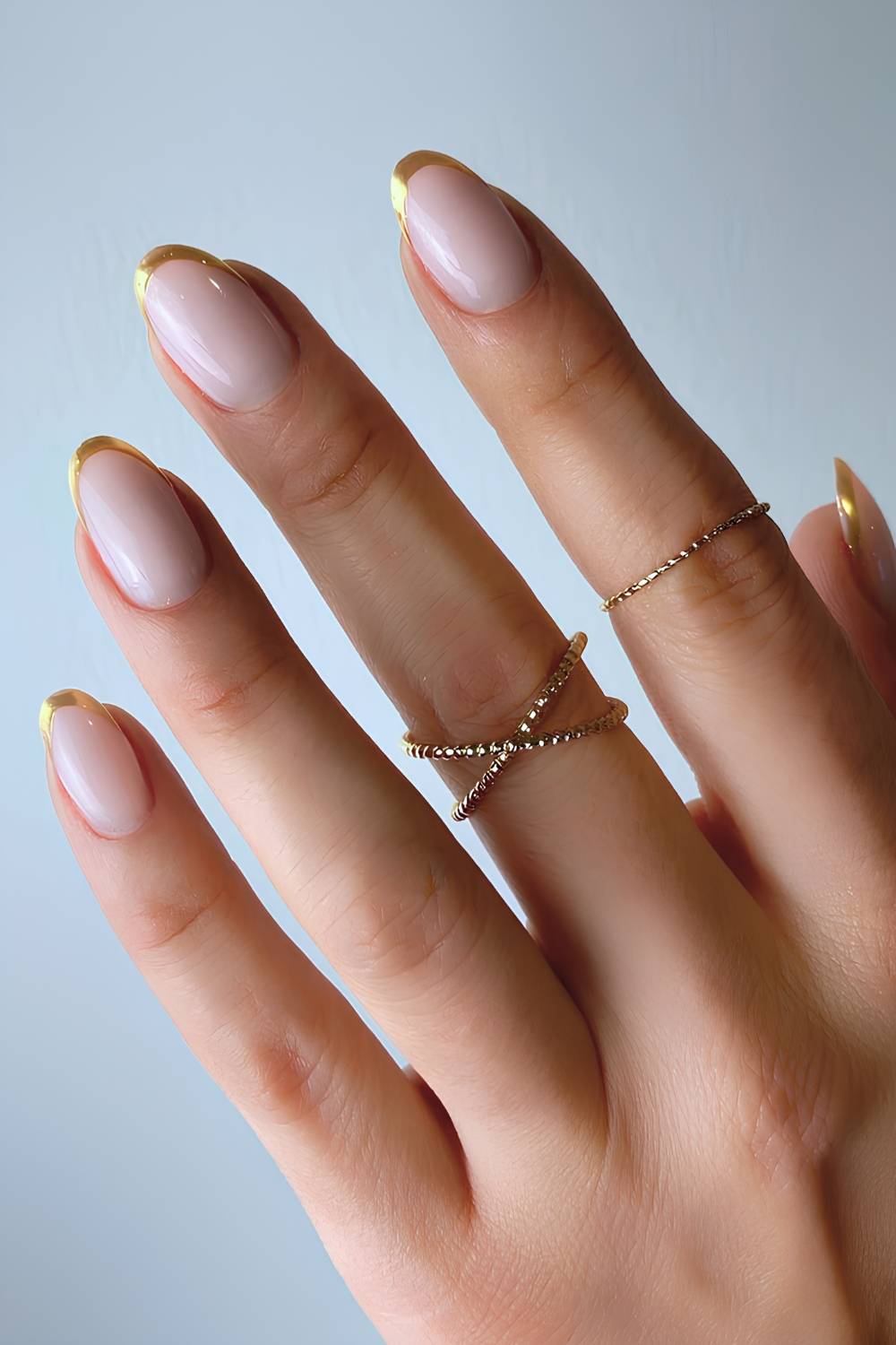 Gold chrome French mani on a milky base