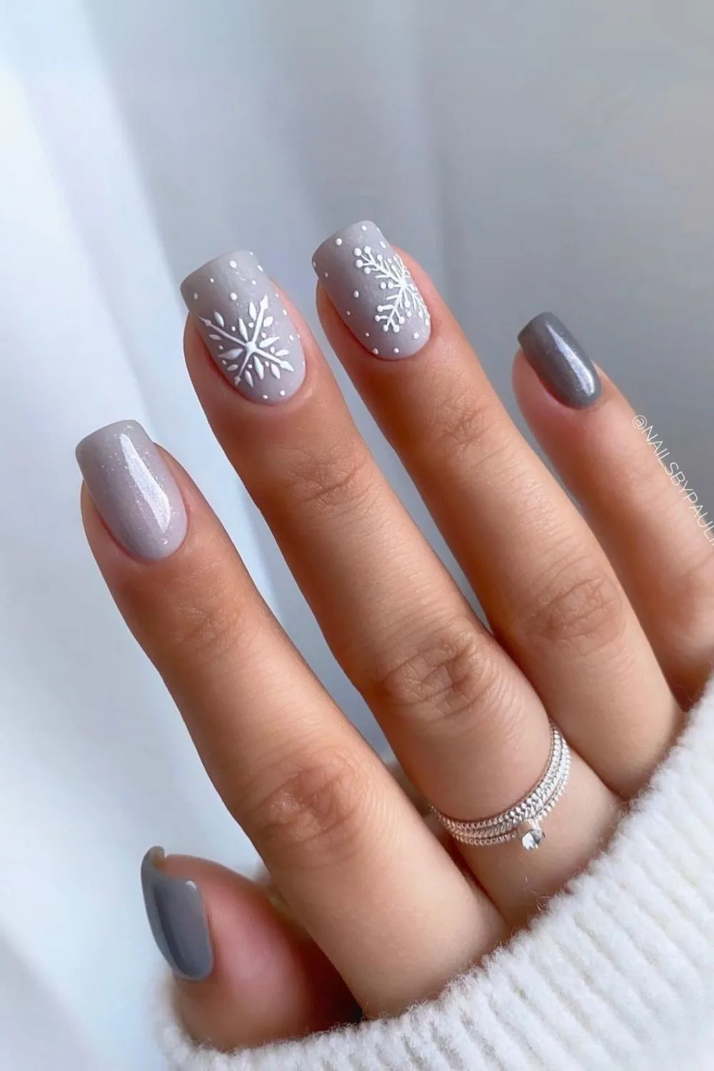 Gray nails with white snowflakes