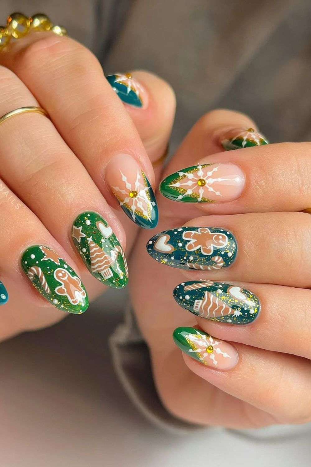 Green French tip nails with gingerbrad and candy canes and christmas tree accents paired with rhinestones