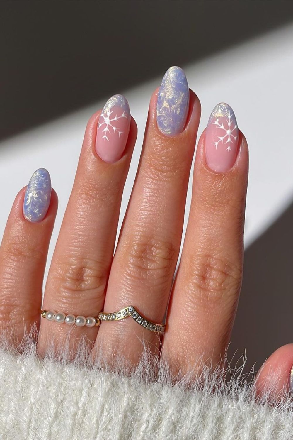 Icy and pearly French tip nails with snowflake accents