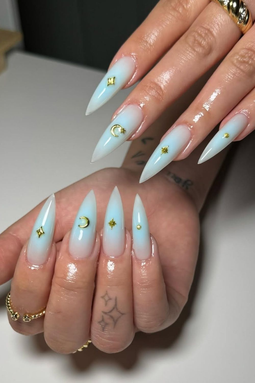 Light blue aura nails with gold accents