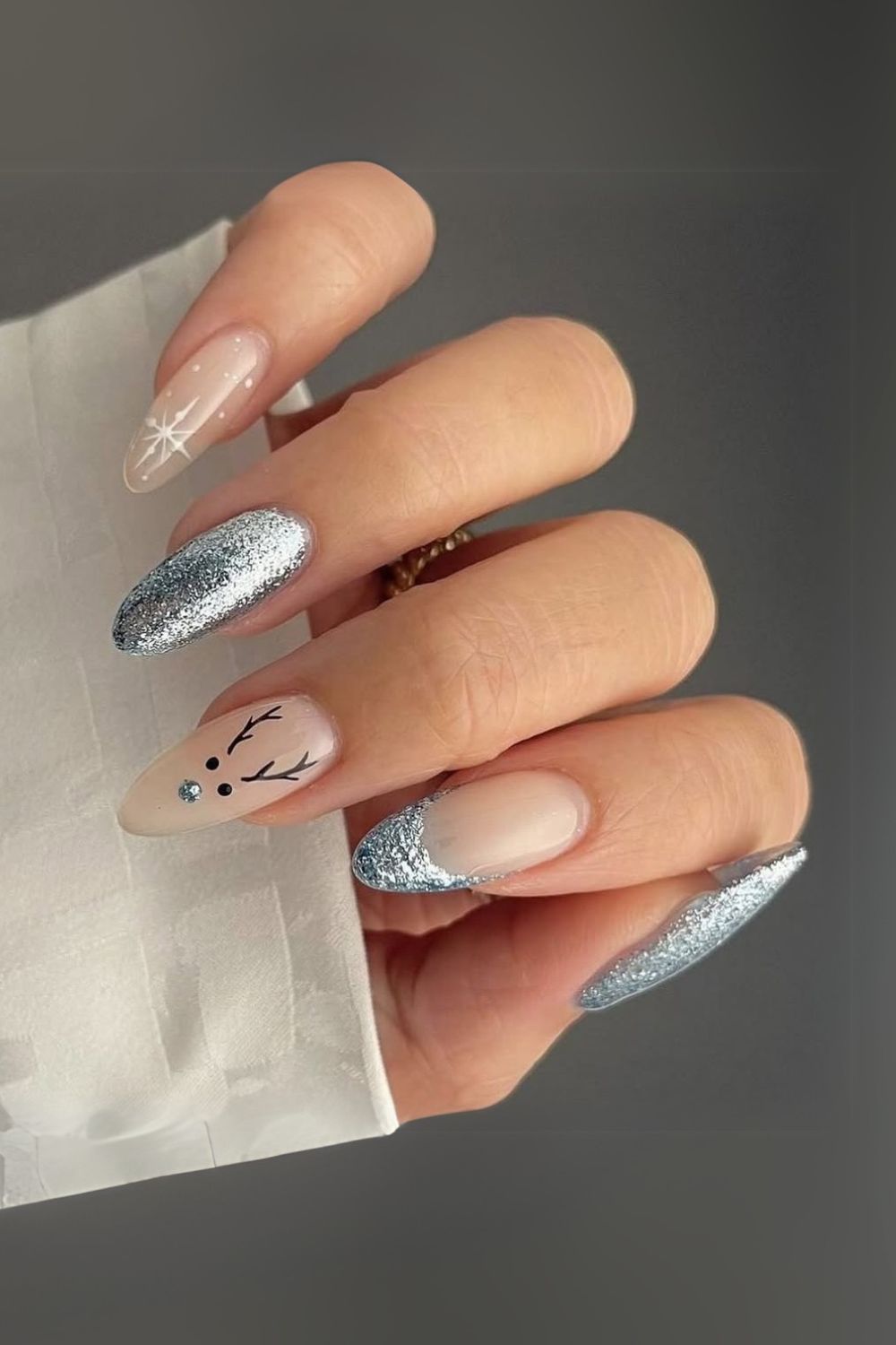 Light blue nails with white snowflakes and reindeer accent nail