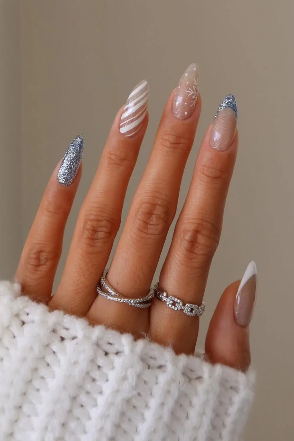 Light gliterry blue and white nails with white candy cane stripes accent nail