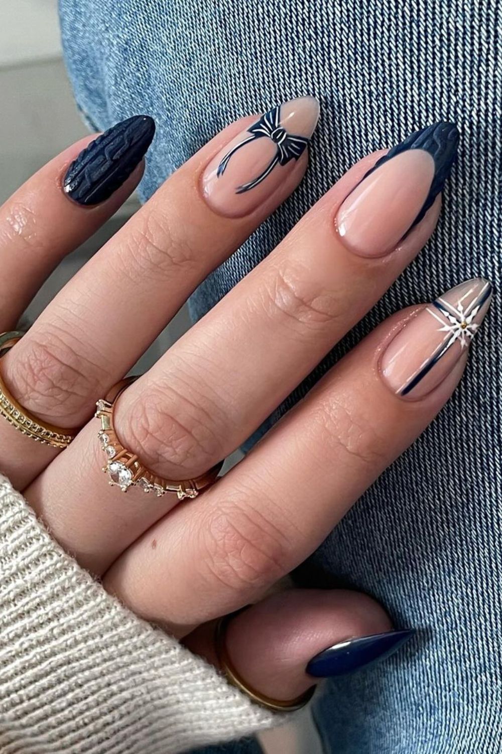 Matte navy blue with a cable-knit effect, paired with nude nails with navy bow accent