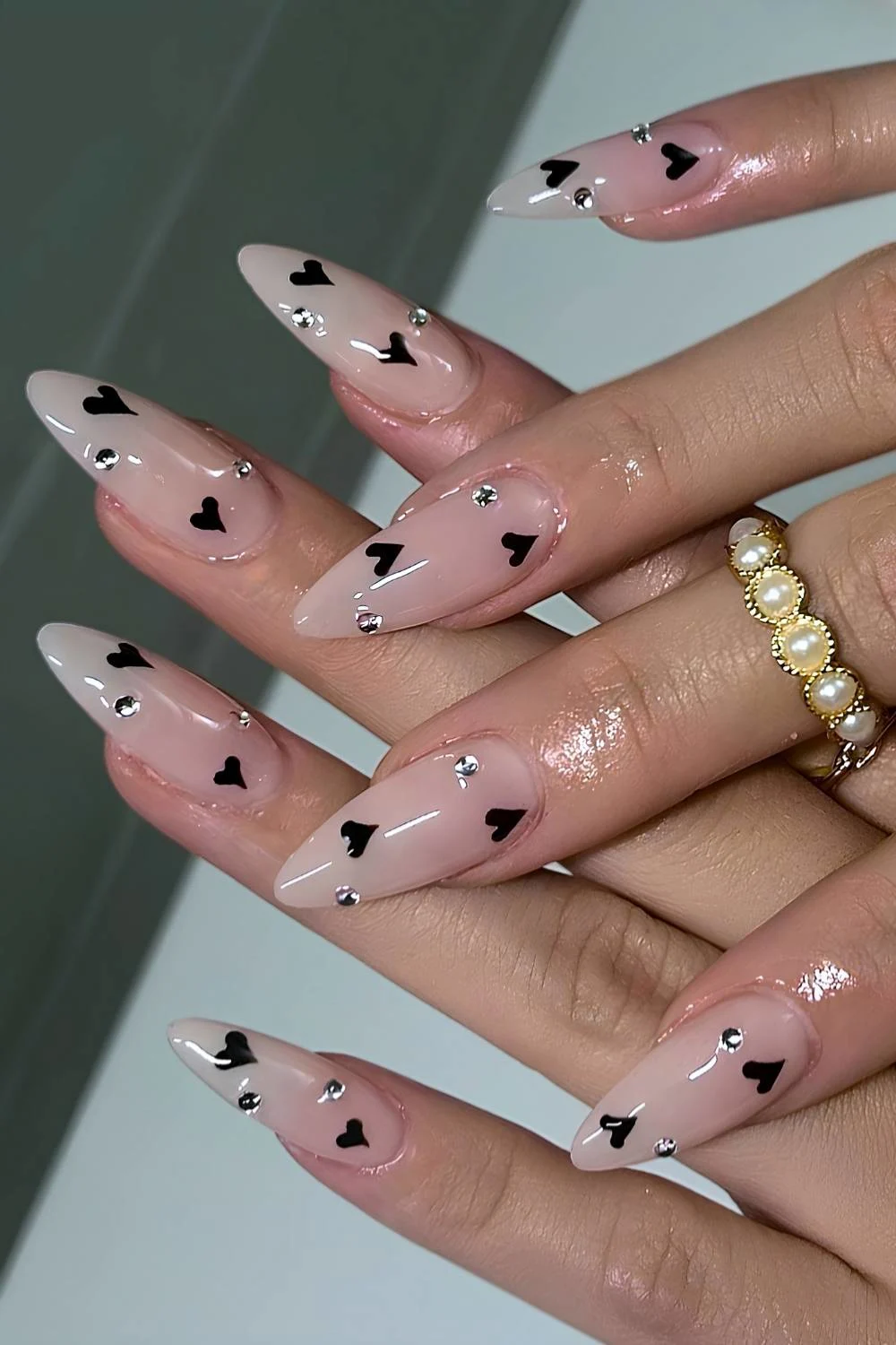 Milky nails with black hearts and rhinestones
