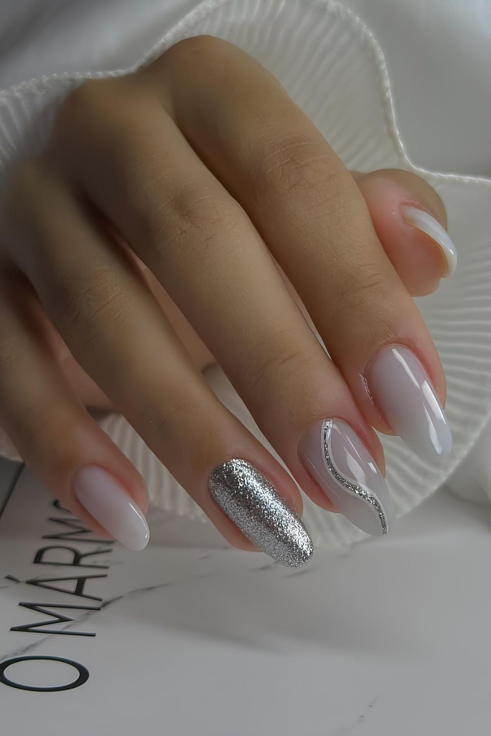 Milky nails with silver glitter accents