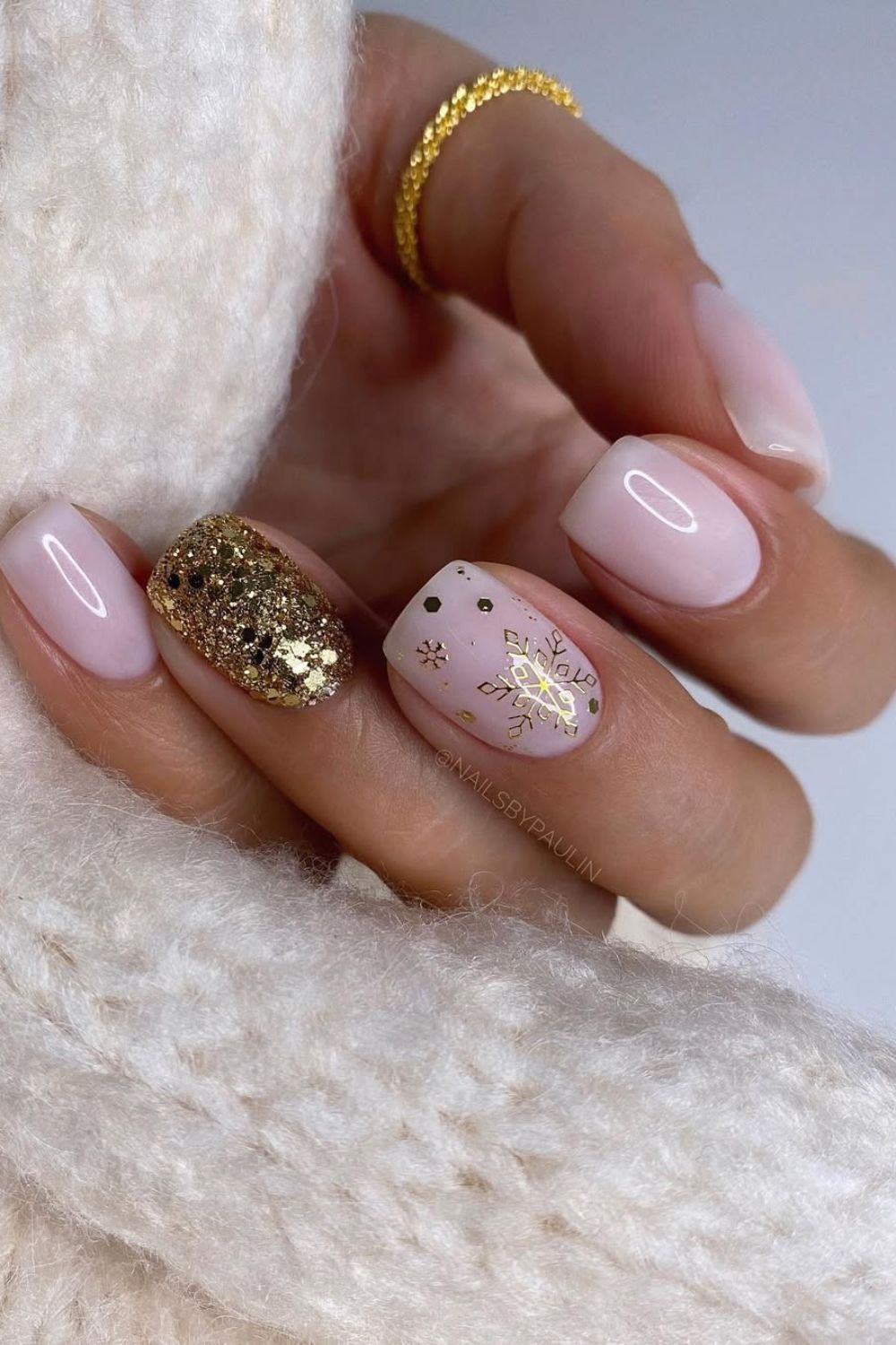 Milky pink nails with glittery gold accent nail and snowflake accent nail