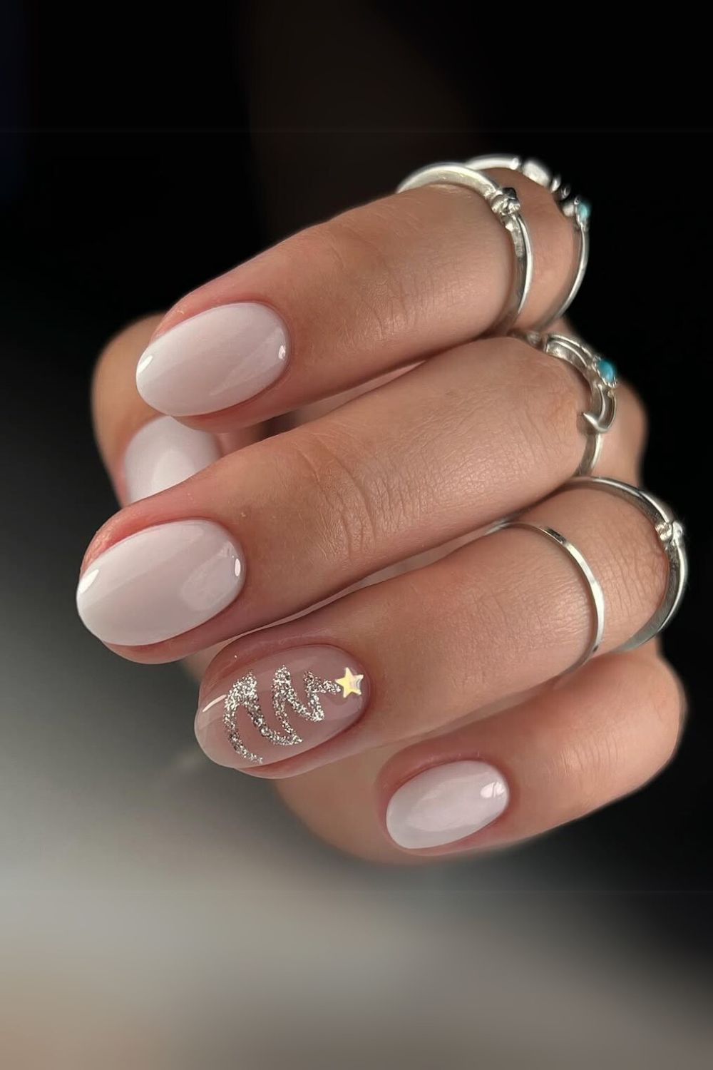 Milky white nails with silver Christmas tree accent