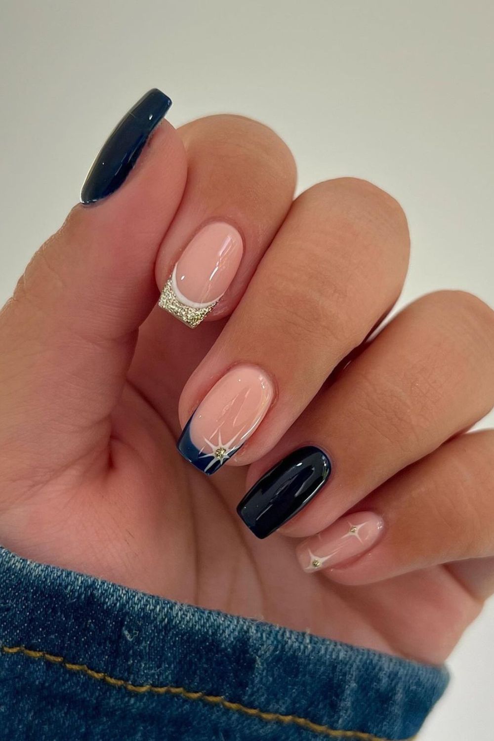 Navy blue and gold French accent nail with celestial design