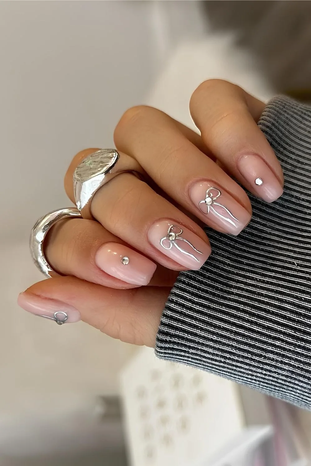 Nude mani with silver bows and rhinestones