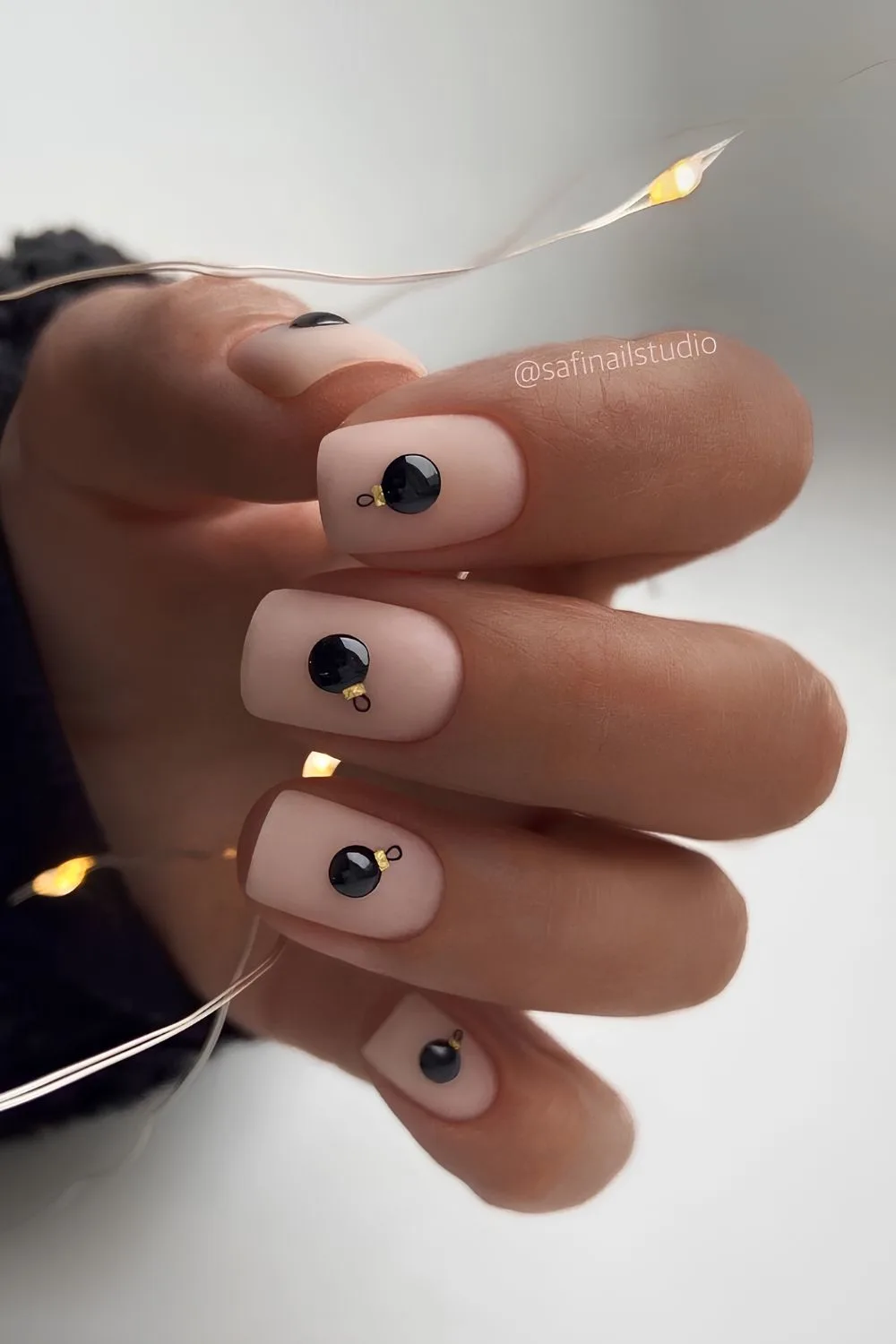 Nude nails with black Christmas bauble art