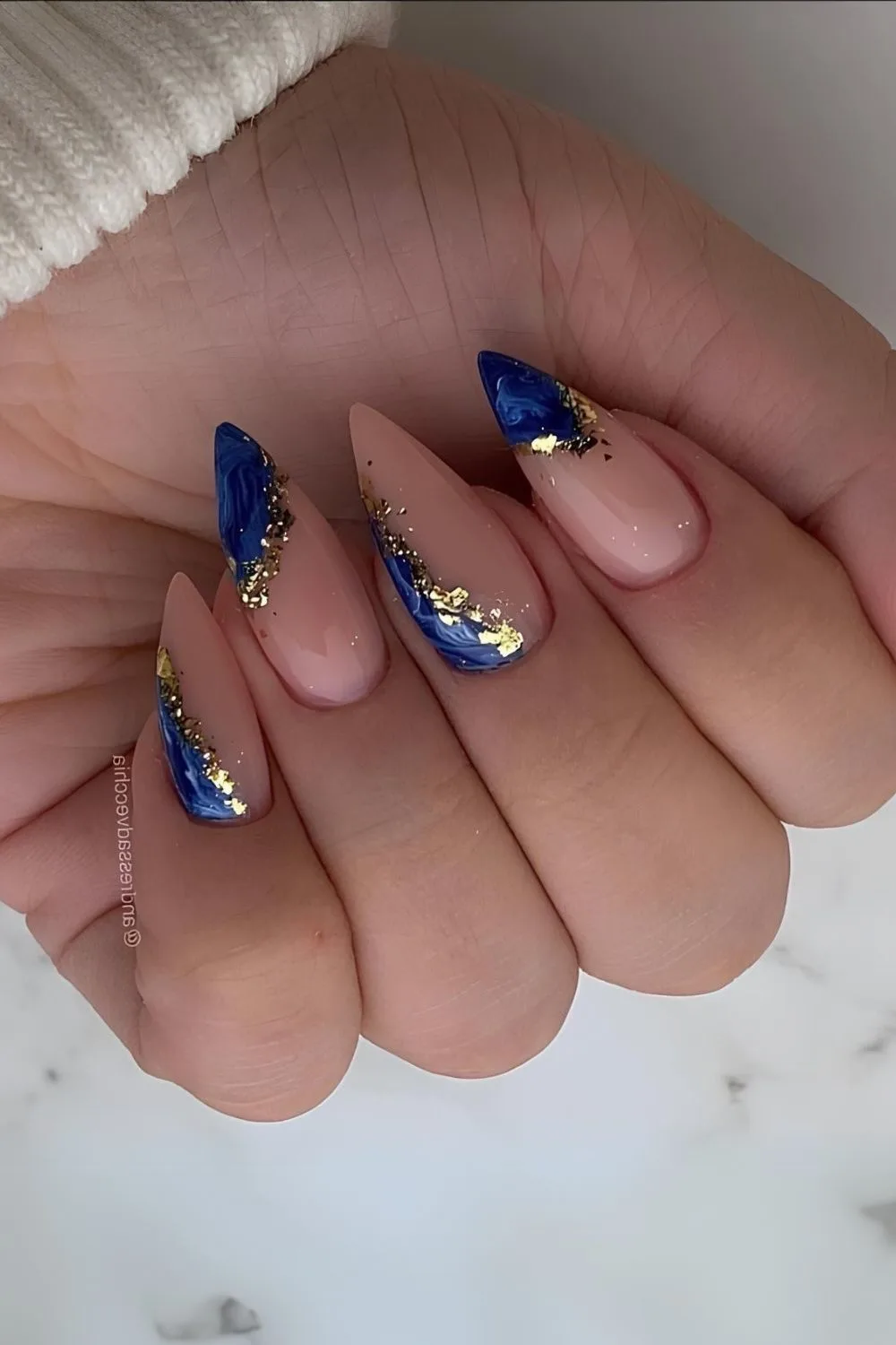 Nude nails with blue and gold marble accent