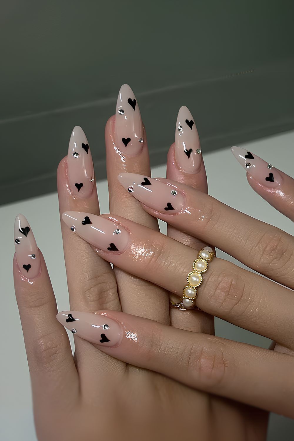 Nude nails with rhinestones and black hearts